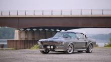 Серебристый Ford Mustang Eleanor под мостом через речку